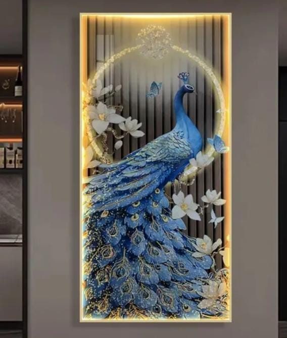 Tall backlit panel of a sapphire peacock among white blossom, glowing with a warm LED halo